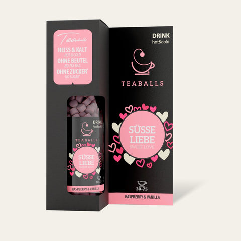 Aromatic TEABALLS - Vanille & Himbeere - Sommergenuss tea blend in a white ceramic teapot with steam rising, surrounded by raspberries and vanilla pods
